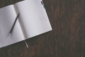 A notebook and pen across in a diagonal fashion