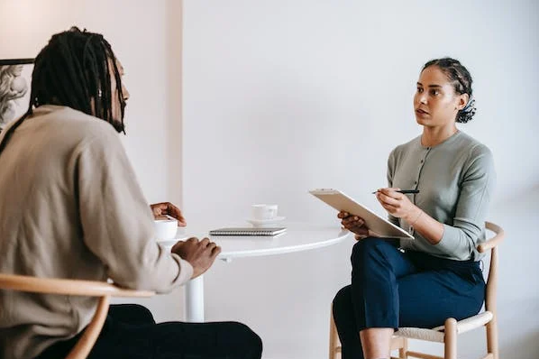 Man and women talking with women holding clipboard