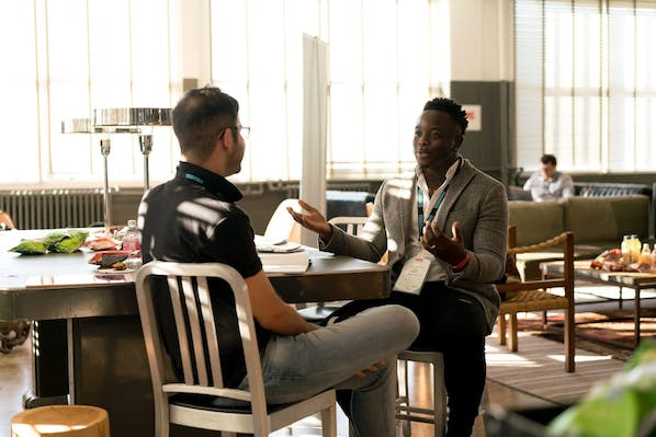 Two men sitting across from each other talking